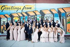 a group of people standing in front of a mural