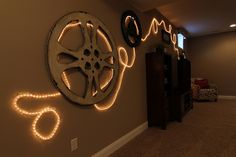 there is a movie reel on the wall with some lights around it that are lit up