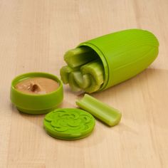 an image of a green vegetable cutters on the table with dip in it and two slices cut out