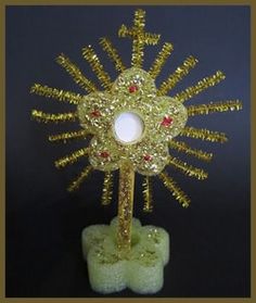 a gold and red christmas tree decoration on top of a green stand with snowflakes