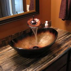 a bathroom sink sitting on top of a wooden counter