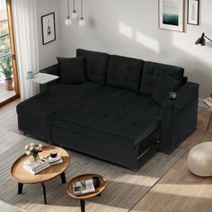 a living room with a black couch and coffee table on the floor in front of it