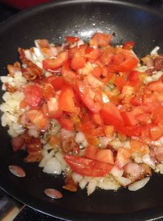 chopped tomatoes and onions cooking in a wok on the stove top with other ingredients