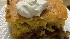 a close up of a piece of cake on a plate with whipped cream on top