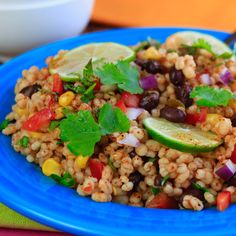 a blue plate topped with rice, beans and veggies next to a fork