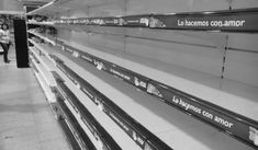 empty shelves in a grocery store with people walking by