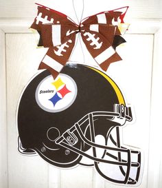 a door hanger with a football helmet on it and a bow hanging from the front