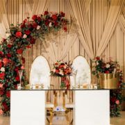 an altar decorated with red flowers and greenery