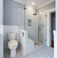 a white toilet sitting next to a walk in shower