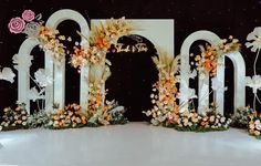 an image of a wedding stage setting with flowers on the front and back wall,