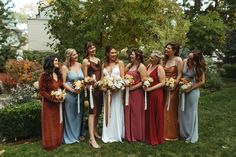 a group of women standing next to each other on top of a lush green field