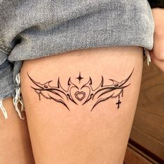 a woman's thigh with tattoos on it and a cross in the middle,