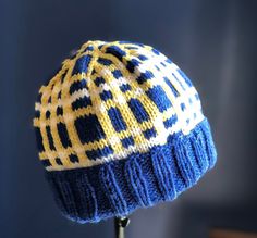 a blue and yellow knitted hat sitting on top of a table