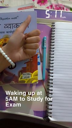 a hand holding a pen next to a notebook with the words waking up at 5am to study for exam