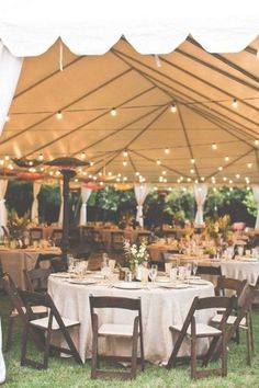 a large tent with tables and chairs under it