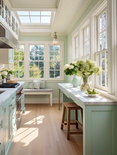 a kitchen filled with lots of counter top space and white cabinets next to a window