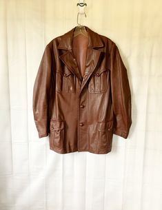 Cool vintage leather jacket in mahogany brown. 1960s or 1970s. Nice detailing in the design elements. Sheen to the soft leather. 4 pockets in front with button closures. Lined with an acetate type fabric. Chest/armpit to armpit is 42 inches. Bottom edge of the leather is 46 inches. Sleeve is 24 inches long. Shoulder to shoulder seam is 17-1/2 inches. Length is 31 inches. Faux belted back. A touch of wear to the edge of the back of the collar and the top of the right arm, not very noticeable. Som Retro Brown Leather Jacket For Fall, Retro Single Breasted Leather Jacket, Retro Brown Outerwear For Work, Retro Brown Leather Jacket For Work, Retro Brown Outerwear With Pockets, Vintage Single Breasted Leather Jacket, Retro Brown Blazer With Pockets, Retro Brown Fall Blazer, Vintage Brown Retro Single Breasted Outerwear