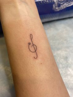 a small musical note tattoo on the arm