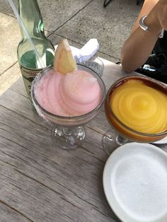 two drinks are sitting on a wooden table