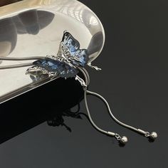 This silver necklace is adorned with a black and blue butterfly. Its length is adjustable for a perfect fit. Elevate your look with this stunning piece that effortlessly combines elegance and charm. The delicate butterfly adds a touch of whimsy to any outfit, making it a versatile accessory for any occasion. Whether you're dressing up for a special event or adding a unique flair to your everyday style, this adjustable silver necklace is sure to become a cherished part of your jewelry collection.  The price is for a necklace only, others are not included. Elegant Black Butterfly Charm Necklace, Elegant Silver Butterfly Necklace With Charm, Elegant Black Butterfly Necklace, Butterfly Shaped Necklace With Adjustable Chain For Parties, Butterfly Necklace With Adjustable Chain For Parties, Elegant Silver Butterfly Necklace With Butterfly Clasp, Elegant Blue Butterfly Jewelry, Party Butterfly Necklace With Adjustable Chain, Elegant Adjustable Necklace With Butterfly Charm