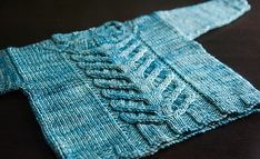 a blue knitted sweater sitting on top of a table