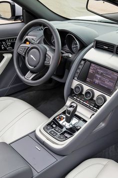 the interior of a modern car with leather seats and steering wheel, including an electronic display