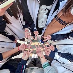 a group of people standing in a circle with their hands on top of each other