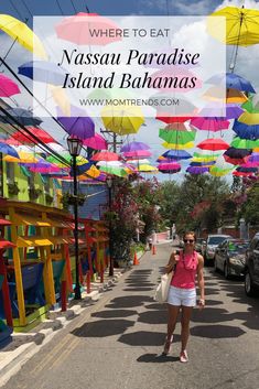 a woman is walking down the street in front of many colorful umbrellas with text overlay