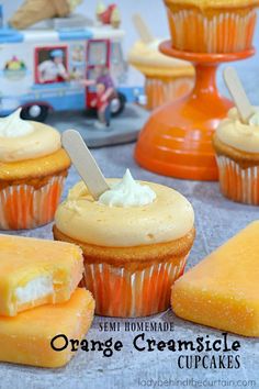 several cupcakes with frosting and popsicle sticks sticking out of them