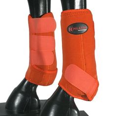 a pair of boots with orange straps on top of each boot and one foot wearing an orange shoe cover