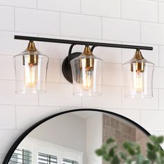 a bathroom vanity with two lights and a mirror on the wall next to it,