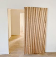 an empty room with a wooden door and hard wood floor