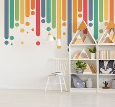 a room with a book shelf and colorful wallpaper