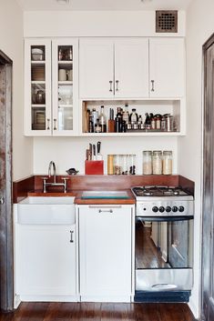 a kitchen with white cabinets and wooden counter tops