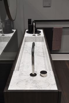 a bathroom sink with a marble counter top and chrome faucet in the middle