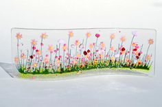 a glass plate with flowers and grass in it