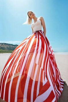 a woman in a red and white dress on the beach