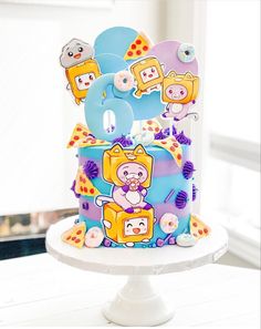 there is a cake decorated with cartoon characters on the top and bottom tier, along with other decorations