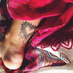 a woman's foot with a tattoo on her left ankle and an intricate design