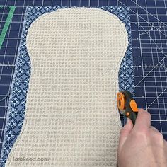 someone cutting fabric with scissors on top of it