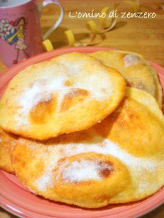 some fried food on a pink plate next to a cup