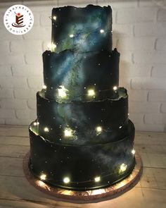 a three tiered cake with lights on it