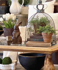 a table topped with lots of potted plants and other decorating items on top of it