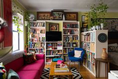 a living room filled with lots of furniture and bookshelves next to a window