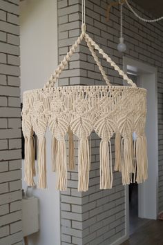 a white macrame hanging from a brick wall