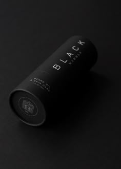 a bottle of black wine sitting on top of a dark surface with the word black printed on it