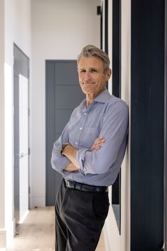 a man leaning against a wall with his arms crossed