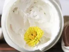 a yellow flower is in the center of a white bowl with ice cream on it