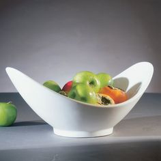 a white bowl filled with lots of different types of fruit on top of a table