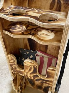 an old wooden cabinet with american flags and pillows on the bottom shelf in front of it